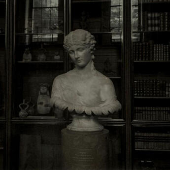 focuses on an open book being held by the passenger of a train. in the background, a rainy scene can be seen racing passedl